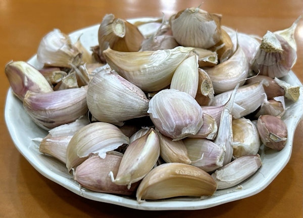 ニンニクをかじりながら蘭州牛肉麺を食べる