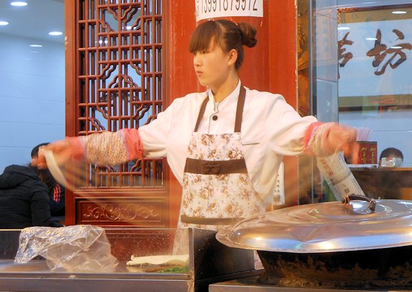 素早く麺を打つ回民街の女性